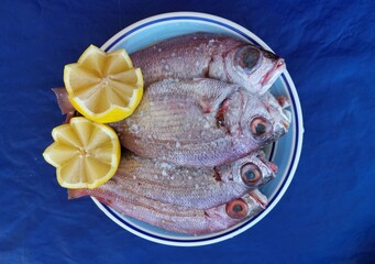 Prato de peixe cru temperado com sal e limão para fritar.