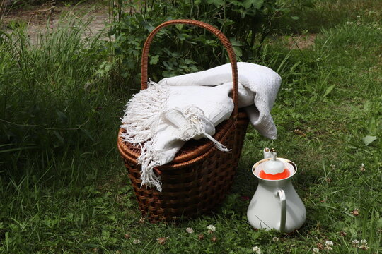 basket and kittle for picnic on green grass 