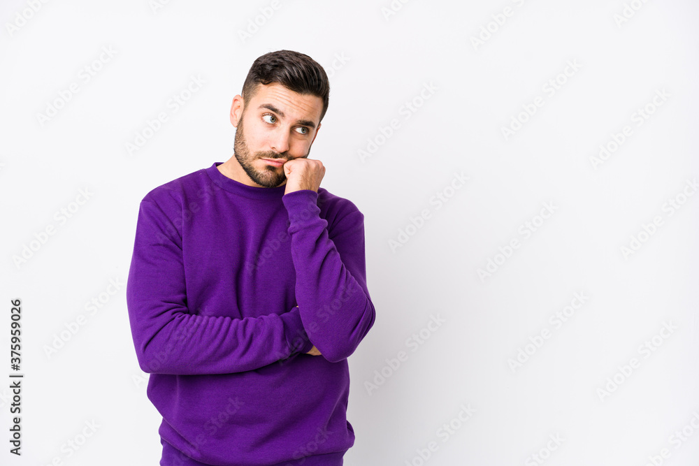 Wall mural Young caucasian man against a white background isolated who feels sad and pensive, looking at copy space.