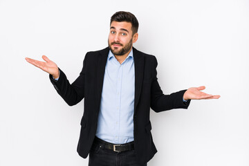 Young caucasian business man against a white background isolated doubting and shrugging shoulders in questioning gesture. - obrazy, fototapety, plakaty