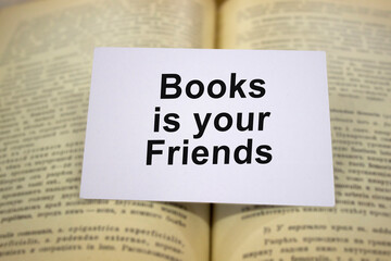 Books is youe friends written in white note on open book