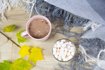 Cocoa and marshmallows. Autumn concept top view. Hot cocoa or hot chocolate with marshmallows on old wooden boards. Coffee, cocoa, hot chocolate, autumn leaf, cozy blanket