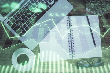 Financial market graph and top view computer on the desktop background. Double exposure. Investment concept.