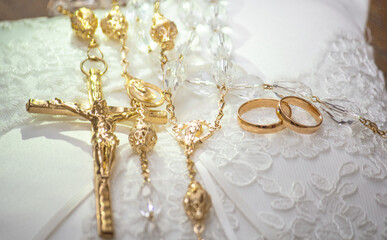 gold rings and cross on the wedding cushion