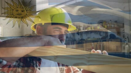 Uruguay flag over site worker carrying wood beam. - Powered by Adobe