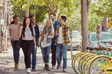 Smiling coworkers walking on sidewalk during lunch break on street