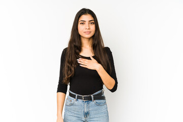 Young indian woman isolated on purple background taking an oath, putting hand on chest.