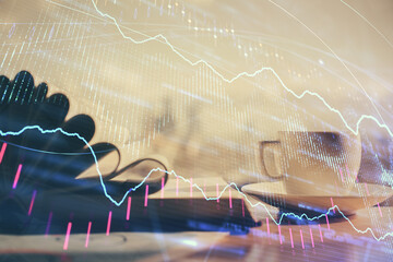 Double exposure of financial chart drawing and desktop with coffee and items on table background....