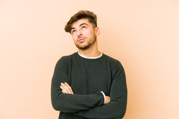 Young arabian man isolated on a beige background tired of a repetitive task.