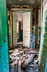 Ruined corridor with piles of garbage in abandoned building