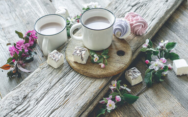 Cups with cocoa and marshmallows and flowers