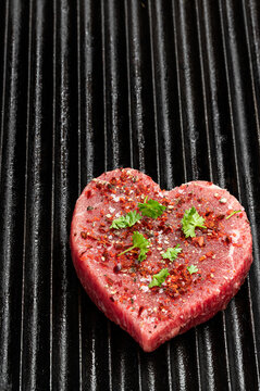 Naklejki Heart shaped raw beef meat with spices on grill tray. Healthy lifestyle or organic food concept for meat lovers.