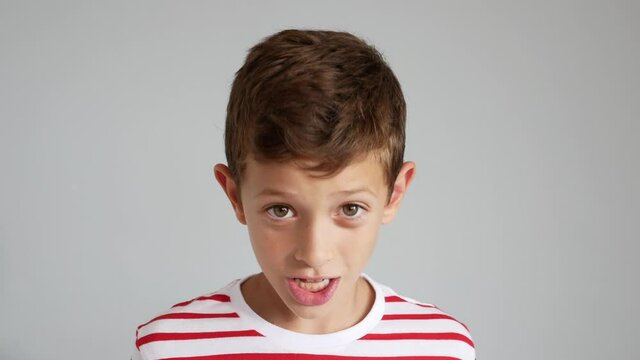 Video Of A 7 Year Old Boy Talking To The Camera, Isolated On Gray Background