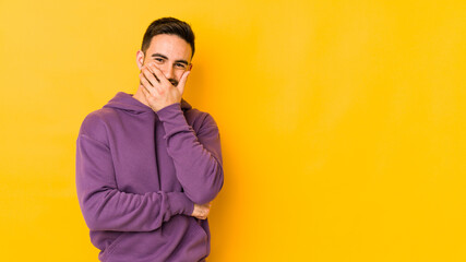 Obraz premium Young caucasian man isolated on yellow bakground laughing happy, carefree, natural emotion.