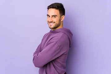 Obraz premium Young caucasian man isolated on purple background happy, smiling and cheerful.
