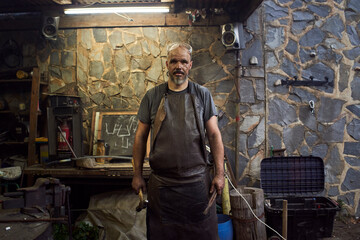 Portrait of a blacksmith in his smithy.