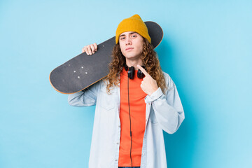 Young caucasian skater man isolated pointing with finger at you as if inviting come closer. © Asier