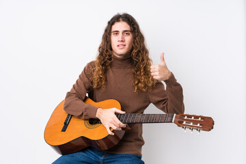 Young caucasian man playing guitar isolated smiling and raising thumb up