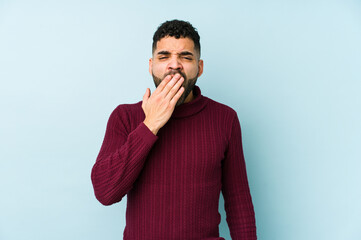 Young mixed race arabic man isolated yawning showing a tired gesture covering mouth with hand.