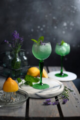Sparkling Woodruff Drink in a glass . green woodruff drink with ice cubes on black background.