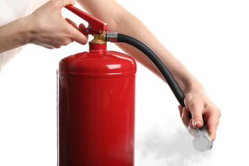 Woman using fire extinguisher on white background, closeup