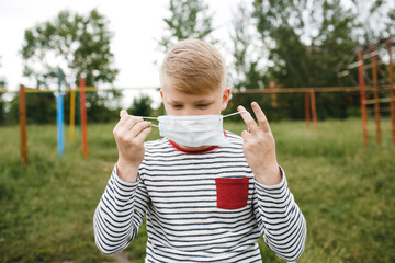 Boy in medical mask. Concept of quarantine and protection from polluted air. Coronavirus, illness, infection. Quarantine and protection virus, flu, epidemic COVID-19.