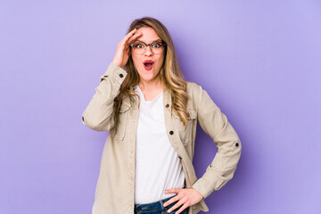 Fototapeta premium Young caucasian woman isolated on purple background shouts loud, keeps eyes opened and hands tense.