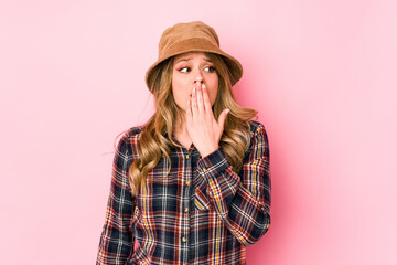 Young caucasian woman wearing a hat isolated yawning showing a tired gesture covering mouth with hand.