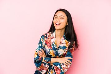 Young chinese woman wearing a asiatic pijama isolated showing a dislike gesture, thumbs down....
