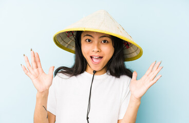 Young chinese woman wearing a vietnamese hay isolated pointing to the side