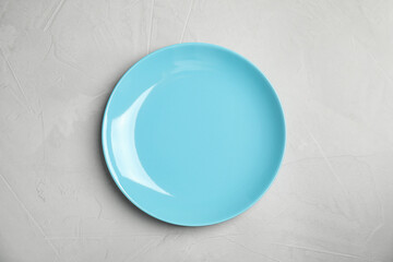 Empty  blue plate on light grey table, top view