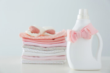 Obraz na płótnie Canvas Detergent and children's clothes on white table