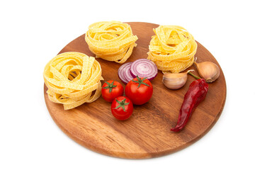 Raw Pasta with ingredients on a wooden chopping Board