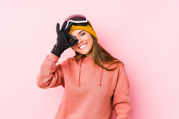 Young caucasian woman wearing a ski clothes isolated excited keeping ok gesture on eye.