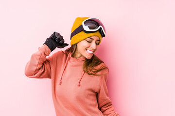 Young caucasian woman wearing a ski clothes isolated dancing and having fun.