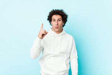 Young sporty man against a blue background having some great idea, concept of creativity.