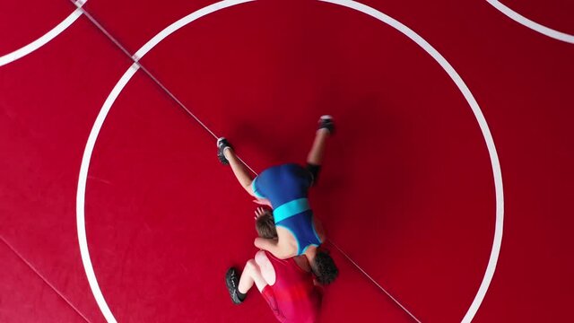 Unique overhead view of youth wrestlers in a live wrestling drill. Blue snaps and hits a two point turn