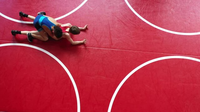 Unique overhead view of youth wrestlers in a live wrestling drill