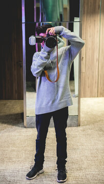 Young photographer selfportrait at big mirror in big wooden room