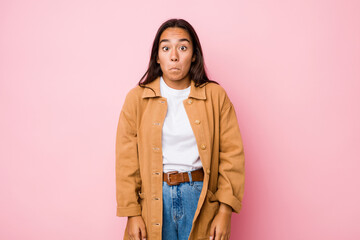 Young mixed race indian woman isolated shrugs shoulders and open eyes confused.