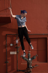Tall young urban female enjoying the sunshine on a city rooftop overlooking Downtown Los Angeles.