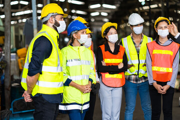 Group of engineers Workers wear protective face masks for safety in machine industrial factory. Worker man wearing face mask prevent covid-19 virus and protective hard hat.