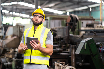 Man at work. Mechanical Engineer  man in Hard Hat Wearing Safety Jacket working in Heavy Industry Manufacturing Facility. Professional Engineer Operating lathe Machinery