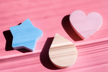 Cosmetic sponges in pastel colors on a pink background with deep shadows. Beauty concept. Copy space