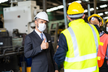 Temperature measurement with employee temperature meter before entering work at factory. Professional engineering team.