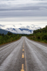 Beautiful View of a scenic road in the Northern Rockies during a sunny and cloudy morning. Taken in British Columbia, Canada. Nature Background
