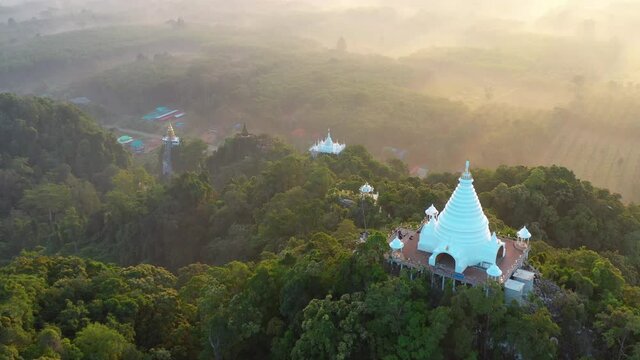 4K drone footage of Buddhism temple Thamma Park padoga on hill at sunrise in Ban Khao Na Nai village in Phanom, Surat Thani, Thailand