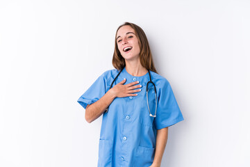 Young nurse woman isolated laughs out loudly keeping hand on chest.