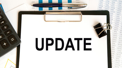 Fototapeta premium The inscription in the UPDATE notebook, around lying markers, glasses, graphics.