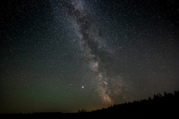 Fototapeta na wymiar Milky Way and stars glowing during a dark black night. Taken in Northern British Columbia, Canada.